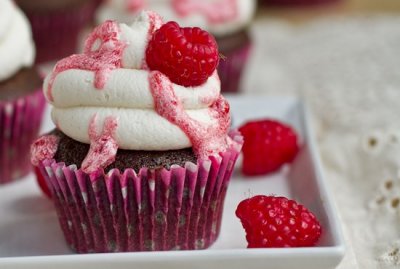 "Chocolate cupcakes topped with fluffy sweet clouds of frosting and a fruity raspberry glaze." Photo: Oh She Glows