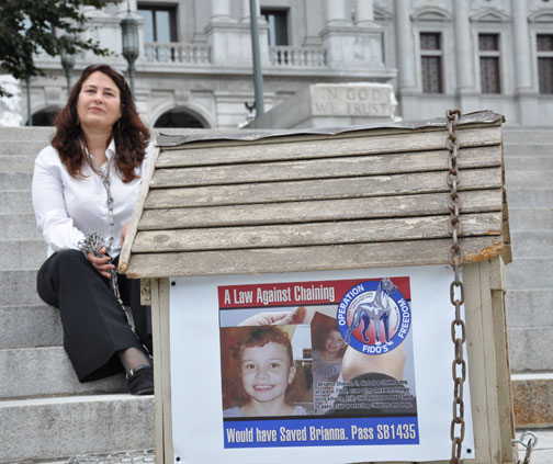 Thayne spent 54 days chained to a dog house outside the Pennsylvania state capitol in an action called "Operation Fido's Freedom," trying to get anti-chaining laws passed. Thayne wrote, "As they remain shackled to one grassless spot 24 hours each day, I will stay chained in front of OUR Capitol (Yes, I believe the Capitol belongs to me too) for ten hours Monday-Friday, 8 a.m.- 6 p.m. As they go without food and water, so will I fast each week from Monday through Friday. And as they are subjected to the elements, so will I be drenched when it rains, wilt in the summer heat, and shiver in the cold of approaching winter." Photo: Dogs Deserve Better